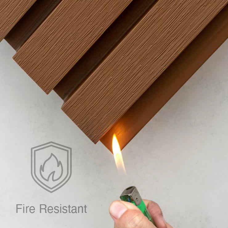 A hand holds a lit lighter under Landmark Decor’s Charcoal Ash Exterior WPC Panel marked “Fire Resistant,” highlighting its weather resistance. A flame icon appears, making it ideal for outdoor wall decoration.