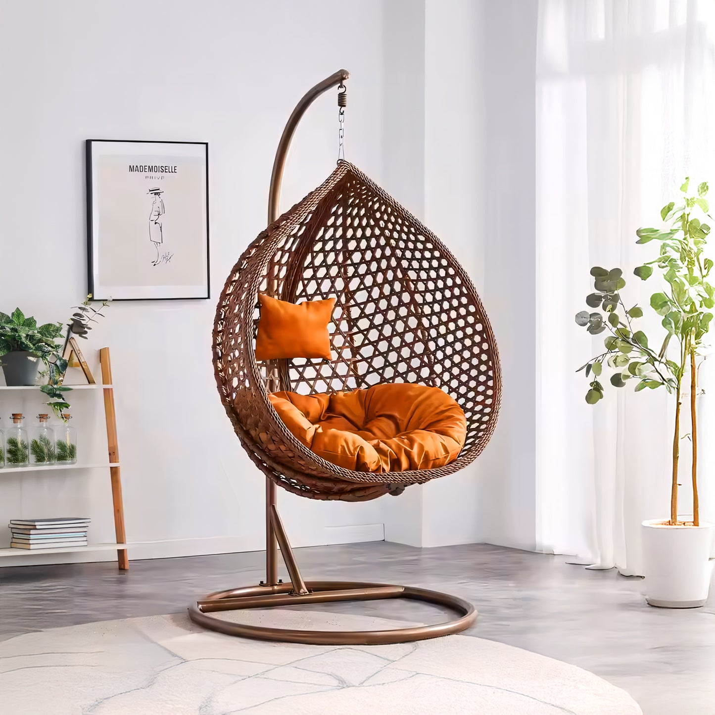 In a bright room, the Landmark Decor Moroccan Outdoor Swing Chair in brown showcases its luxury with orange cushions. Positioned by a sunlit window, it features innovative design elements such as a potted plant and framed artwork that enhance the minimalist space.