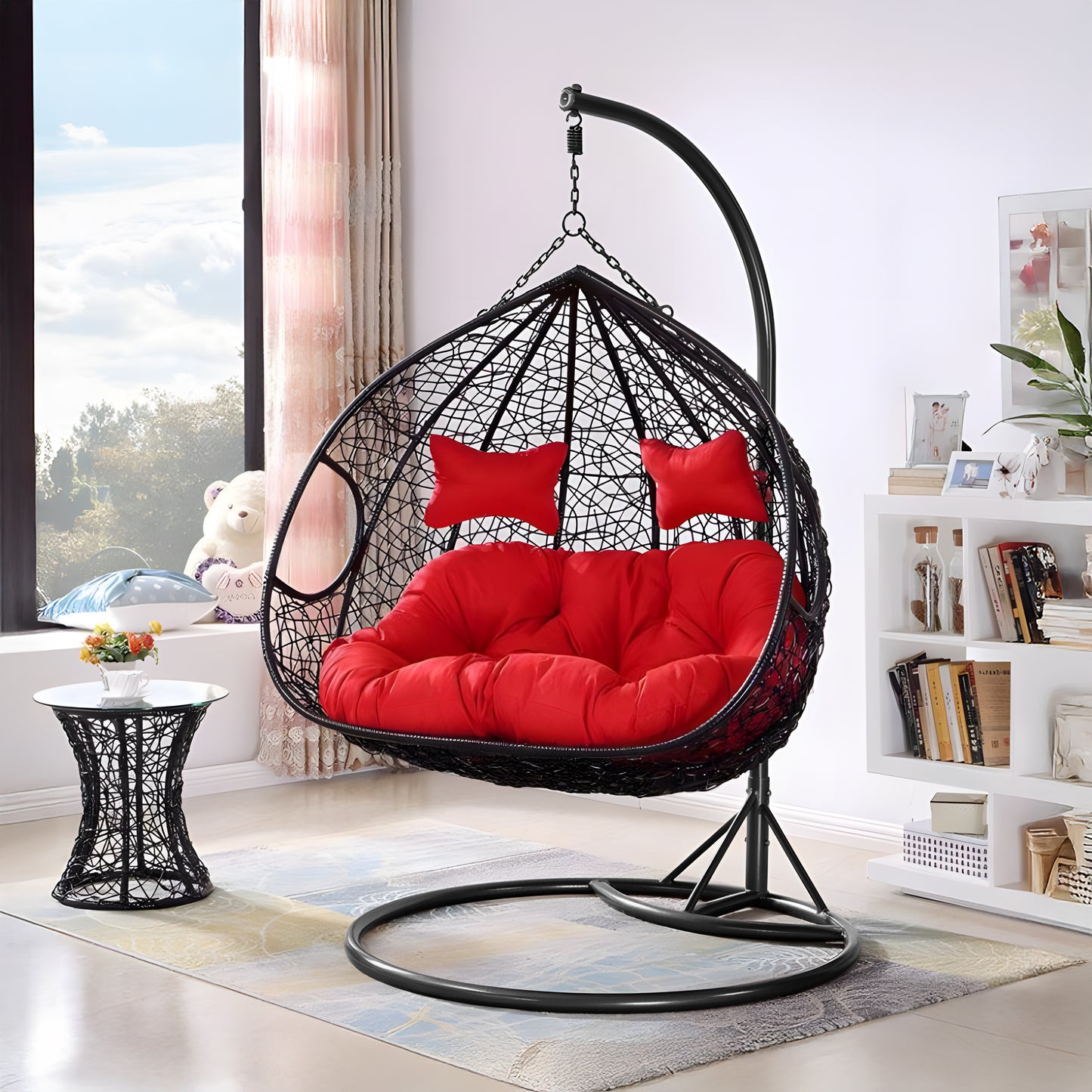 Transform your space into an indoor oasis with the Soho Outdoor Swing Chair by Landmark Decor, featuring bright red cushions and two pillows, suspended from a stylish black metal stand. Complement this luxury piece with a matching wicker side table near a sunny window for the perfect cozy retreat.