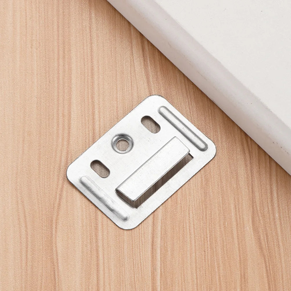 Landmark Decor Interior WPC Panel Clips, featuring a metal bracket with three holes, are secured to a light wood surface beside a white object to provide reliable fastening for wall panel installation.
