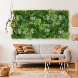 A living room with a light gray sofa, patterned cushions, a white coffee table, a hanging plant, and the Landmark Decor Tropical Green Wall art above the sofa adds a fresh touch of nature.