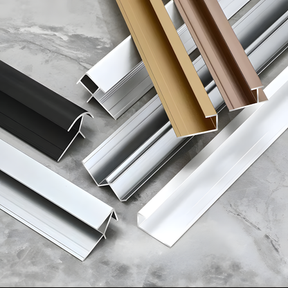 Landmark Decor Carbon Sheet Aluminum Outer Corner profiles in assorted finishes—black, silver, gold, bronze, and white—are displayed on a gray stone surface.