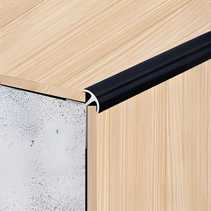 Close-up of panel edges with Landmark Decor’s PVC Wall Outer Corner Strip in black, highlighting the join between wood surface, trim, and composite core—perfect for wall panel installations.