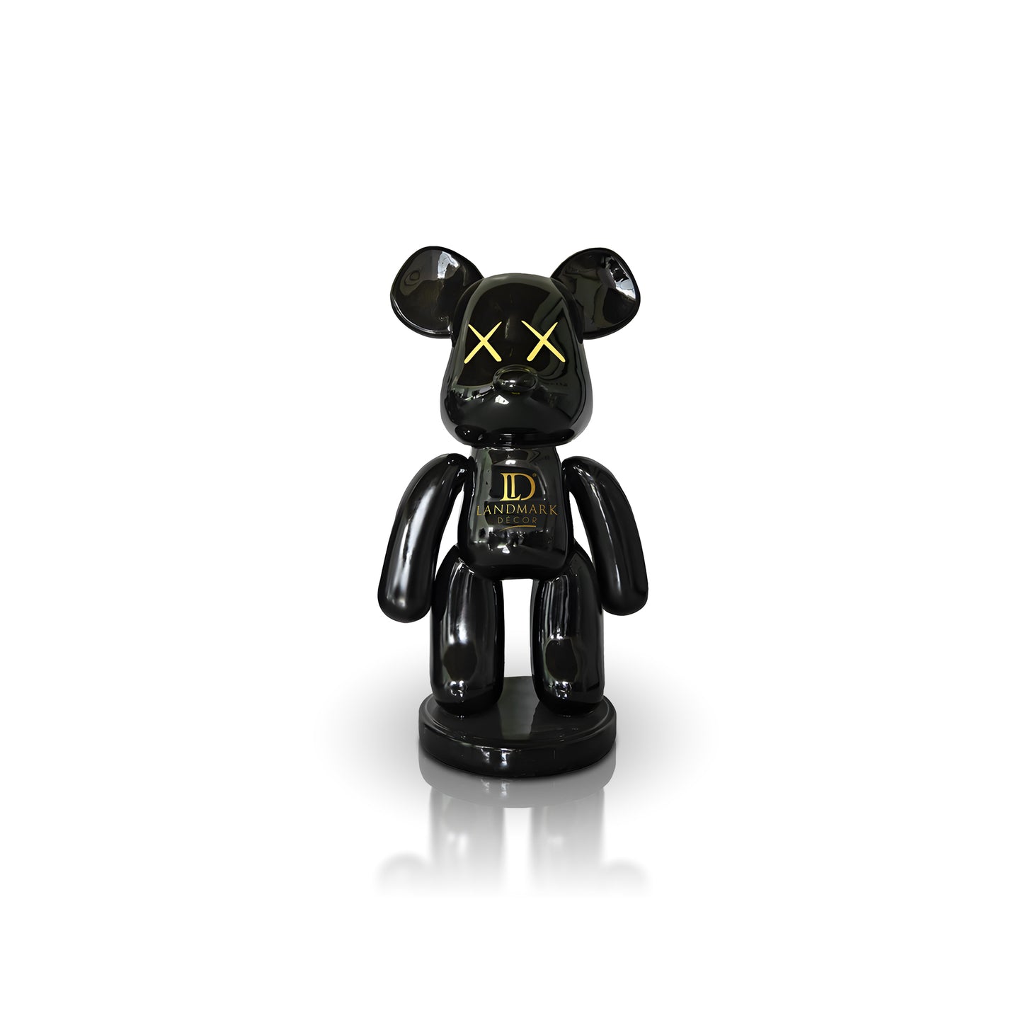 The Black Bear - Medium by Landmark Decor is a glossy black bear-shaped figurine with yellow X eyes and "LANDMARK" on its chest, perfect for adding a bold accent to your space or Landmark Decor collection. Displayed against a white background.