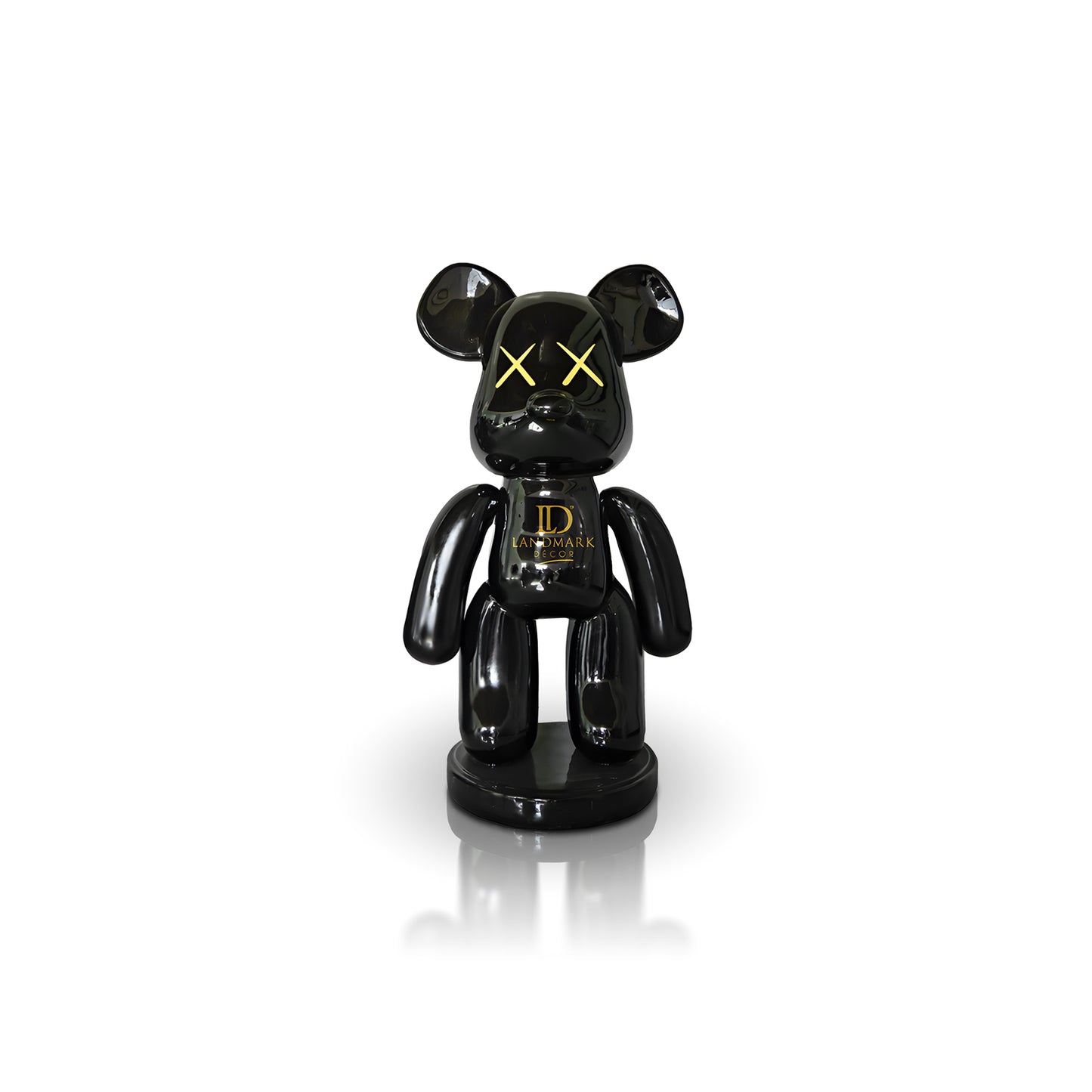 The Landmark Decor Black Bear - Medium is a glossy black bear figurine with yellow X eyes and gold LD Landmark on its chest, making a bold statement in your home when displayed on a white background.