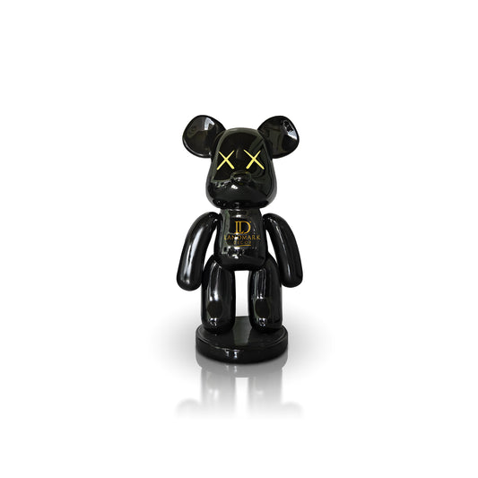 The Landmark Decor Black Bear - Medium is a glossy black bear figurine with yellow X eyes and gold LD Landmark on its chest, making a bold statement in your home when displayed on a white background.