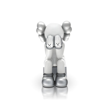 Veiled Thoughts - Electroplated by Landmark Decor features a gray and white cartoon figure with its head down, hands covering its face, and X marks on the hands—an artistic sculpture perfect for standout interior decor.