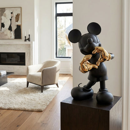 The Heart U - Small by Landmark Decor is a matte black Mickey Mouse statue with shiny gold hands on a pedestal, perfect for adding striking artistic flair to modern living rooms with neutral palettes and large windows.
