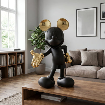 The Welcome Invitation - Small by Landmark Decor, a matte black cartoon mouse statue with shiny gold ears and gloves, sits on a wooden coffee table, bringing artistic flair to this modern living room's decor.