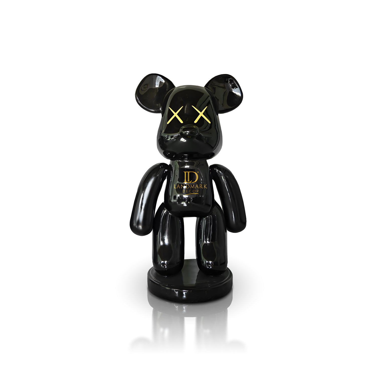 The Black Bear - Large by Landmark Decor is a glossy black bear figurine with yellow X eyes and "LANDMARK" on its chest, standing on a round base—ideal as bold interior decor against a white backdrop.