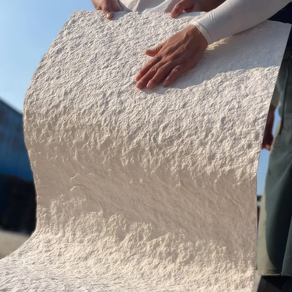 Close-up of hands holding the Landmark Decor Star Moon Stone Sheet in Beige outdoors, showcasing its elegant, soft stone-like texture in natural light.