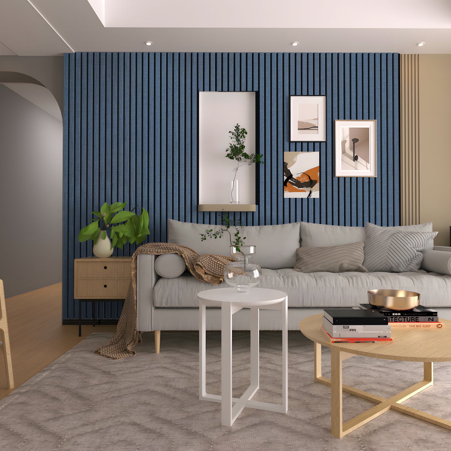 Modern living room with a grey sofa, decorative pillows, framed art, patterned rug, and minimalist coffee tables. The blue textured accent wall features the Landmark Decor Navy Blue WPC Fluted Slat Wall Panel.