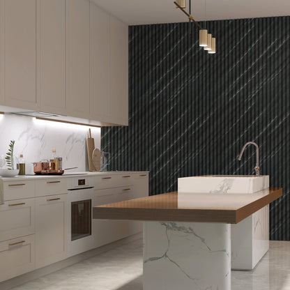 Modern kitchen with white cabinets, marble backsplash and island, brass hardware, wood countertop extension, and a dark accent wall featuring Landmark Decor’s Carbon Black with Diagonal Texture WPC Fluted Slat Wall Panel.