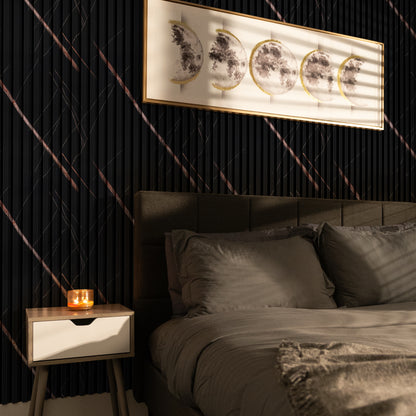 A modern bedroom with a grey bed, a nightstand with a lit candle, and moon phase art on dark accent walls featuring Landmark Decor’s Rosso Noir Vein WPC Fluted Slat Wall Panels.