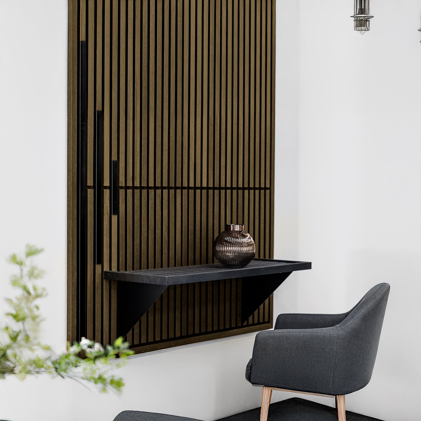 A modern corner features a gray upholstered chair, a black wall shelf with a metallic vase, and Landmark Decor’s Wood Panel Metal Cover-Black on the wall for enhanced modern style.