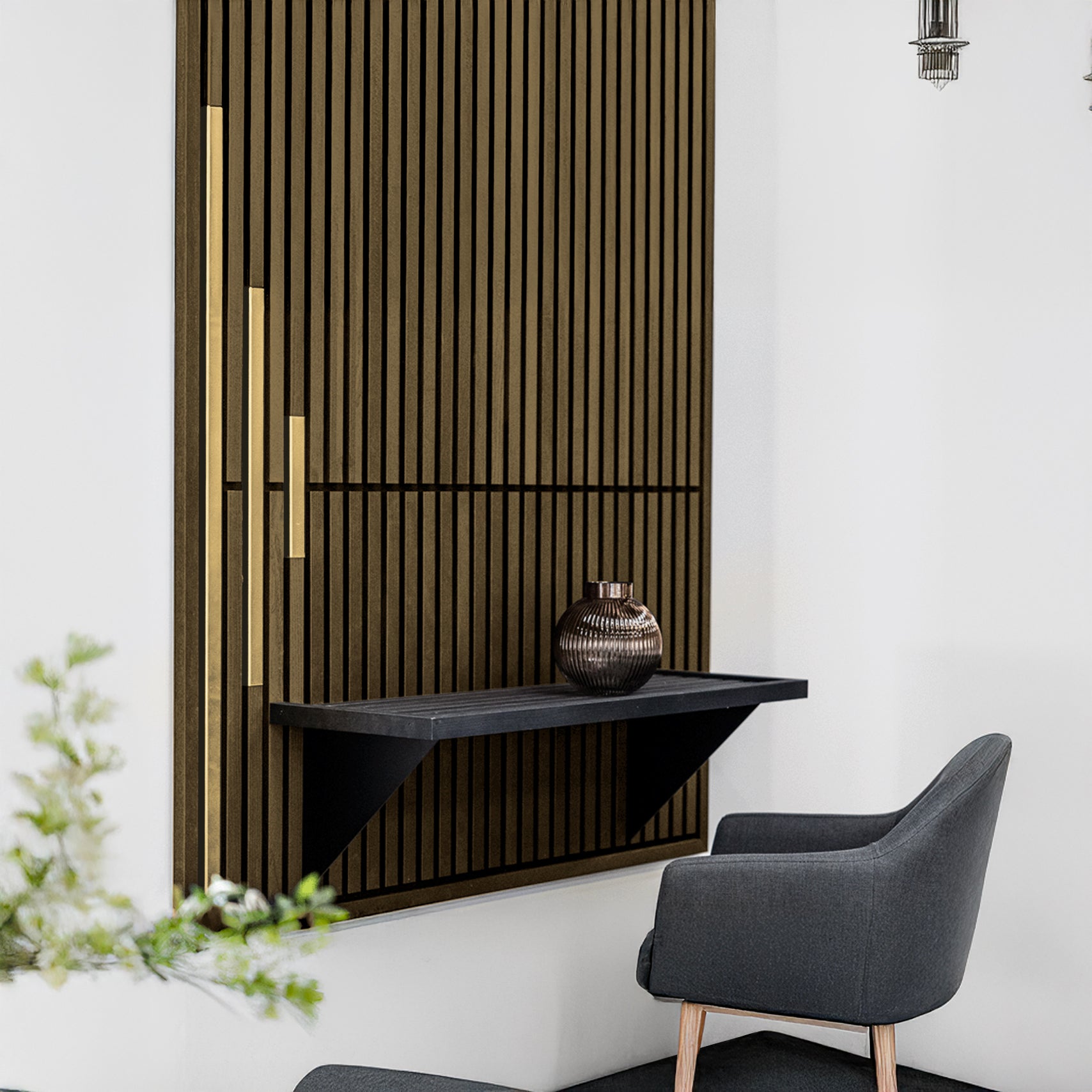 A modern interior features Landmark Decor’s Wood Panel Metal Cover in Champaign Gold as a slat wall, paired with a floating black shelf and gray upholstered chair for an elegant contemporary look.